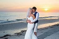 Groom hugging bride on beach