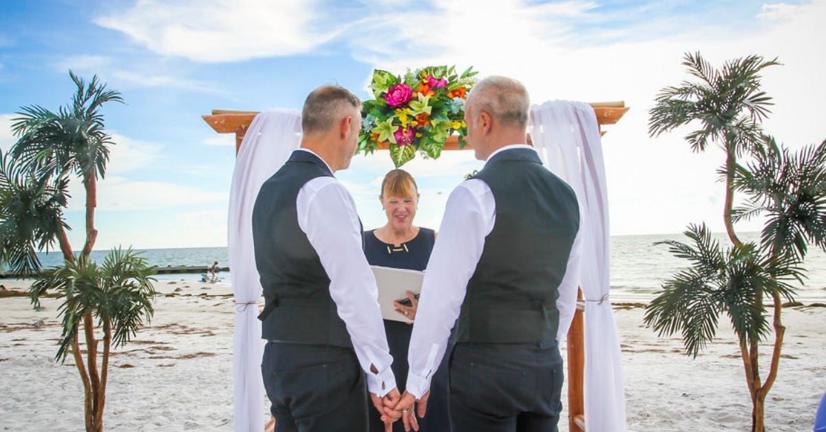 Same-sex wedding on beach at Honeymoon Island by Renee Leigh Photography