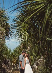 Couple kissing between Palm Trees on Honeymoon Island in Clearwater, Florida